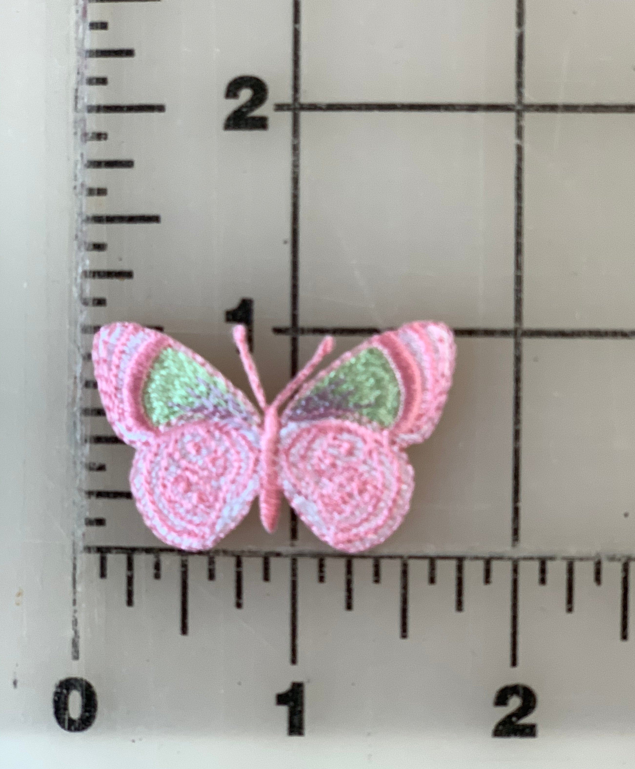 Pink butterfly patch on a ruler.