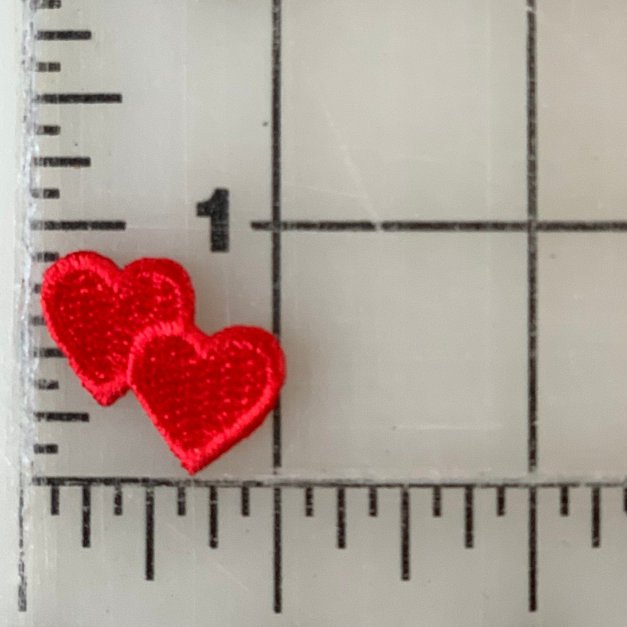 Two small red heart shapes on a ruler.