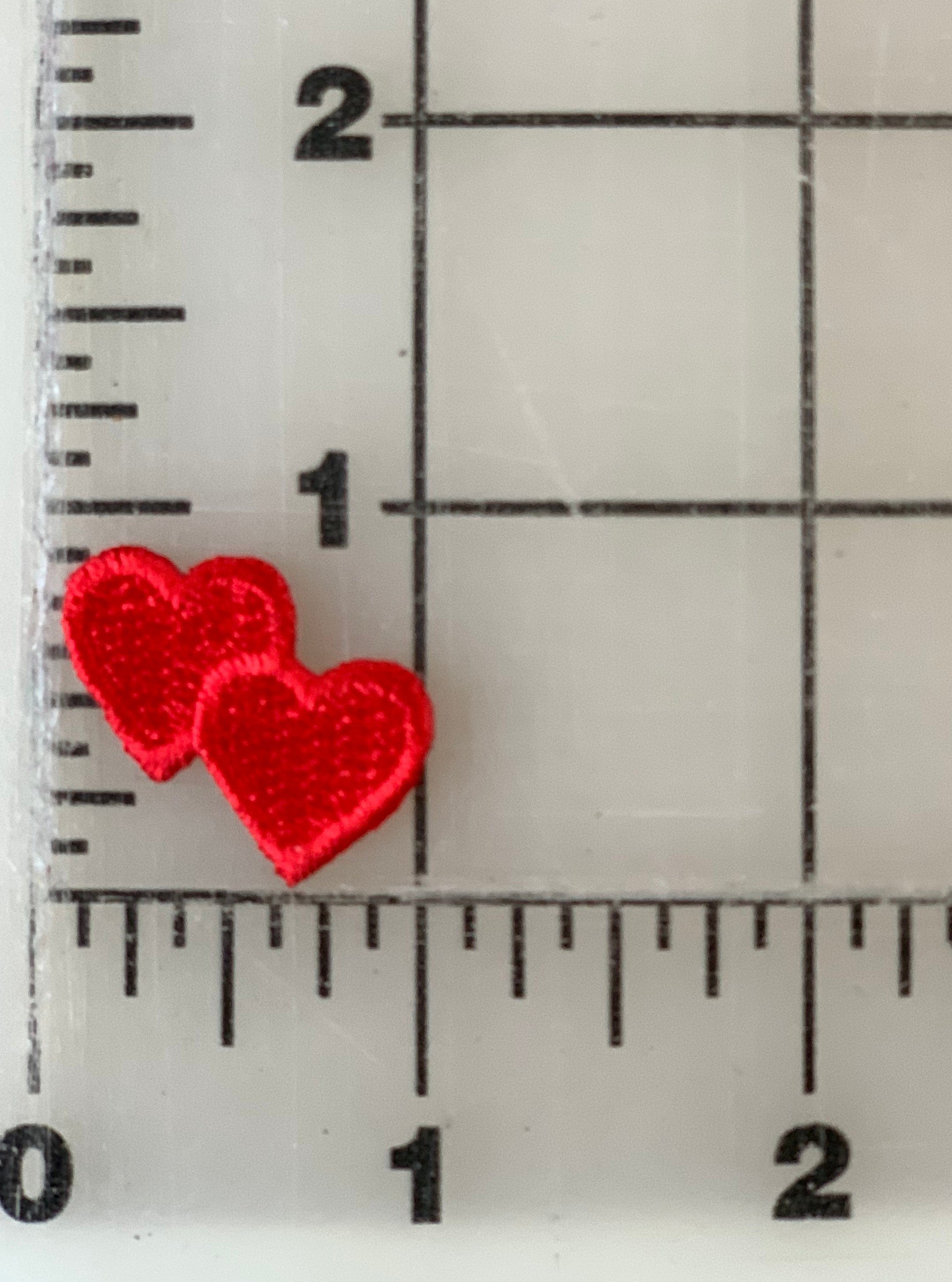 Two small red heart shapes on a ruler.