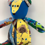 Patchwork teddy bear with a yellow pocket.