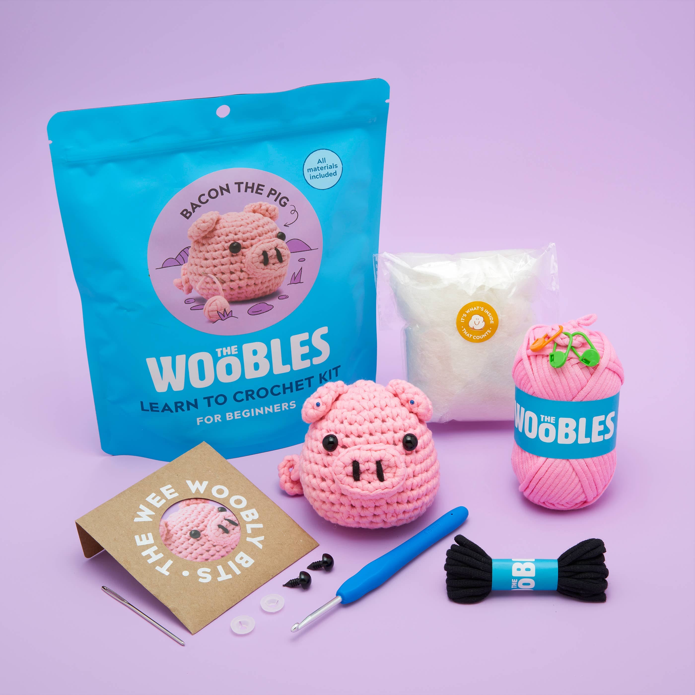 Crochet pig kit with yarn, bag, and accessories.