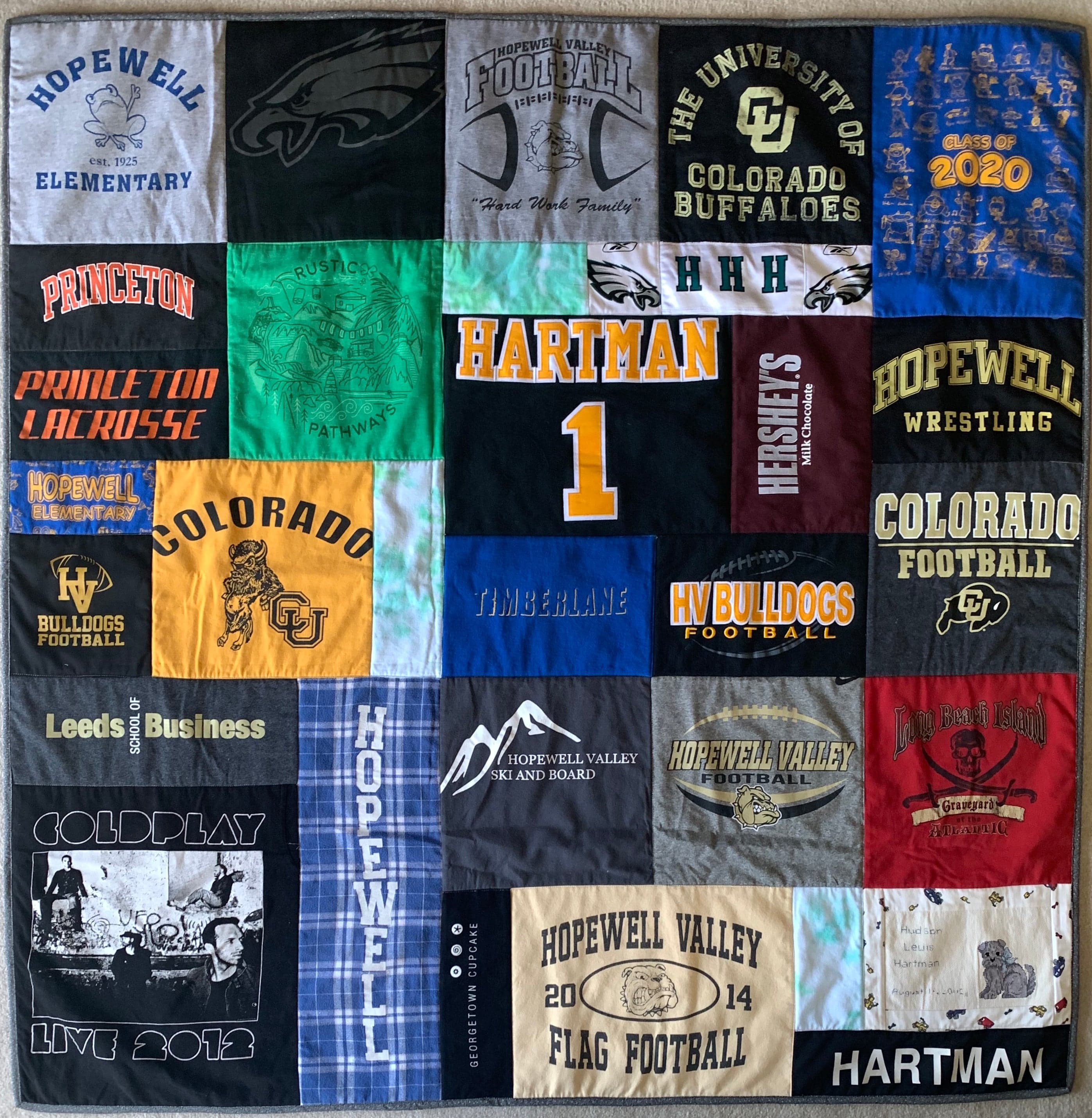 Hartman jersey quilt with various college logos and text.