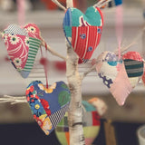 Patchwork heart ornaments hanging from a tree