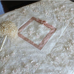 Wedding quilt center with blush ribbon and bouquet